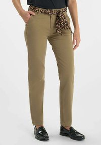 Pantalon khaki ajusté avec une ceinture à imprimé l�éopard. Le tissu est lisse avec un léger éclat, et l'ourlet se trouve au-dessus de la cheville.