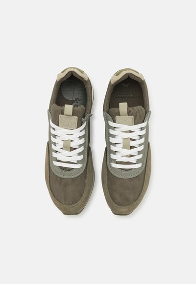 Olivgrüne Netz- und Wildledersneaker mit weißen Schnürsenkeln, einer gepolsterten Zunge und einer strukturierten Gummisohle mit einem Logo-Highlight an der Seite.