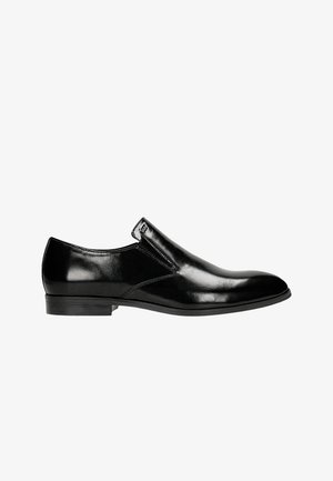 Black leather slip-on shoe with a glossy finish, featuring a rounded toe and minimal stitching detail on the sides. Flat rubber sole.