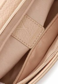 Lichtroze clutch van nep leer met een gestructureerde afwerking, voorzien van een ritssluiting en een gladde stoffen binnenkant. Inclusief een merkembleem.