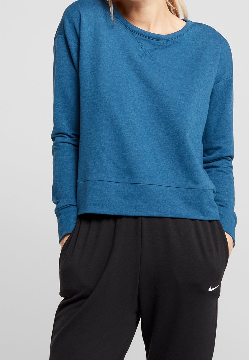 Sweatshirt bleu à manches longues avec un col rond, des épaules basses et une coupe décontractée. Le tissu semble doux avec une texture lisse.