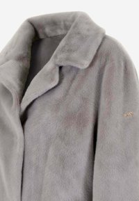 Cappotto in pelliccia sintetica grigia con colletto a scialle, caratterizzato da una texture morbida e un leggero lucore. Include un logo in oro sullmanica.