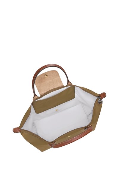 Open brown tote bag with light interior, magnetic flap pocket, and two brown handles visible from above.