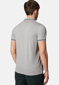 Szary polo z teksturowanej bawełny, z małym haftowanym logo oraz granatowymi paskami na kołnierzyku i mankietach.