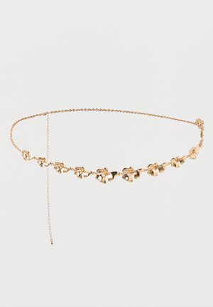 Delicado cinturón de cadena de oro con pequeñas flores enlazadas y una cadena de extensión ajustable sobre un fondo blanco liso.