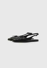 Black slingback shoes made of smooth leather. Features a pointed toe, gathered design on the front, and an adjustable buckle on the strap.