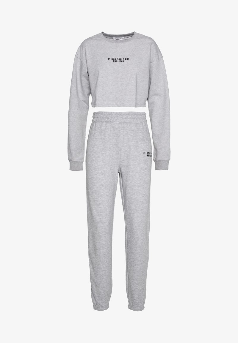 Ensemble lounge deux pièces gris clair avec sweat-shirt court à manches longues et pantalon de jogging à taille élastique, tous deux avec le texte « MISSGUIDED EST. 2009 ».