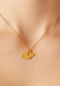 Goldene Halskette mit zwei Herzanhängern, einem größeren und einem kleineren, die eine glatte, reflektierende Oberfläche und eine zarte Kette aufweist.
