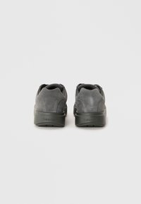 Sive nubuck tenisice s čvrstim tamnosivim đonom. Na poleđini se nalazi Calvin Klein logo, s podstavljenim ovratnikom za udobnost.
