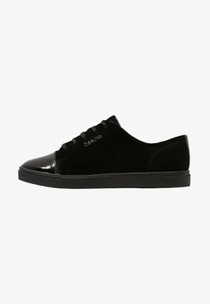 Czarny niski sneaker z cholewką z zamszu, lakierowany noskiem ze skóry, czarnymi sznurowadłami i logo Calvin Klein z boku.