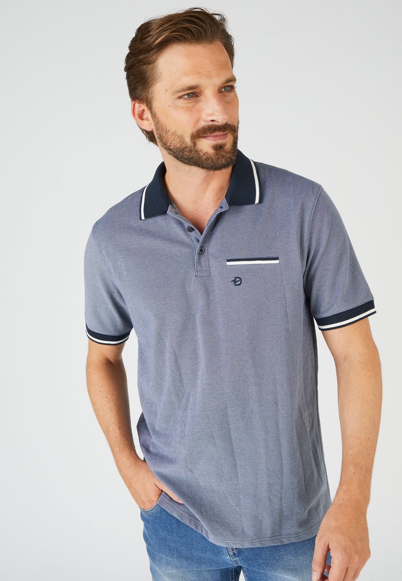 Polo blu navy realizzato in tessuto a trama con strisce bianche di accento sul colletto e sulle maniche, dotato di taschino sul petto.