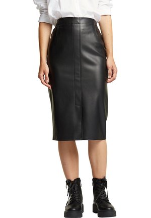 Czarna skórzana midi spódnica o dopasowanym kroju, z detalem w postaci przedniego szwu i gładką fakturą, zestawiona z czarnymi sznurowanymi botkami za kostkę.