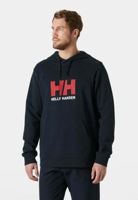 Felpa con cappuccio blu navy con tasca frontale a marsupio, caratterizzata da un audace logo "HH" rosso e bianco. Realizzata in tessuto morbido e strutturato con cappuccio regolabile.