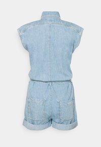 Ljusblå denim jumpsuit utan ärmar med vikta shorts-linningar, två bakfickor och krage, visad från baksidan.