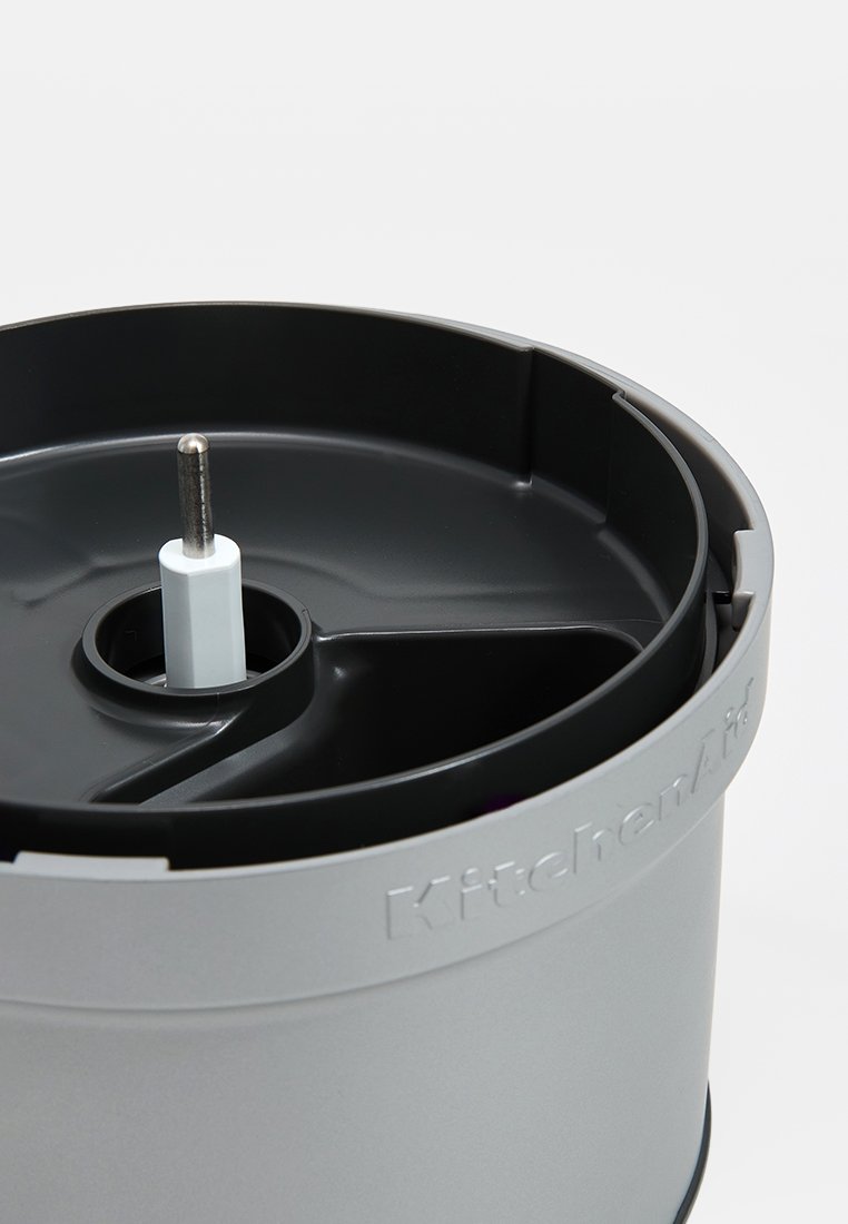 Bol de sorbetière KitchenAid, en plastique gris avec une texture lisse. Spindle central blanc, logo en relief le long du bord, design robuste.