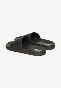 Zwarte slippers van textuur rubber, met twee brede banden en reliëflogo. Platte zool met subtiele accenten. Lichtgewicht ontwerp.