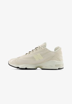 Beigen värinen urheilukenkä, joka on valmistettu mokasta ja verkkomateriaalista. Kenkässä on teksturoitu muotoilu, musta kumipohja ja sivussa näkyvä näkyvä 'N'-logo.