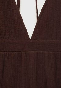 Robe sans manches marron avec un décolleté en V profond, tissu texturé et taille froncée pour une silhouette fluide.