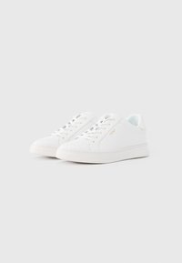 Λευκά δερμάτινα αθλητικά παπούτσια με επίπεδες σόλες, στρογγυλές μύτες και σχέδιο με κορδόνια. Διαθέτουν ελάχιστη σήμανση και λεία υφή.