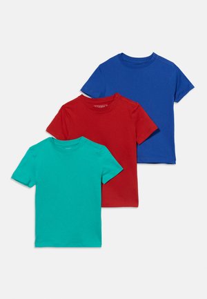 Τρία απλά κοντομάνικα μπλουζάκια με στρογγυλή λαιμόκοψη σε τιρκουάζ, κόκκινο και μπλε χρώμα, τοποθετημένα διαγώνια το ένα πάνω στο άλλο σε λευκό φόντο.