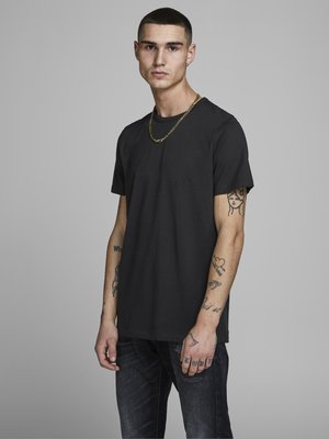Schwarzes Rundhals-T-Shirt aus Baumwolle, mit kurzen Ärmeln und lockerer Passform. Auffällige Details sind eine goldene Kette und sichtbare Tattoos an den Armen.