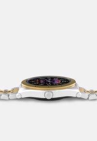 Smartwatch med en sort urskive, guld bezel og et metalarmbånd i sølv og guld. Har et rundt urhus og en fremtrædende krone på siden.