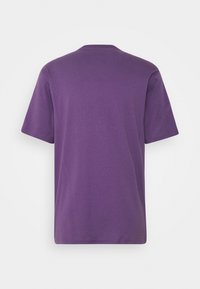 T-shirt violet uni à manches courtes, vu de dos sur fond blanc.
