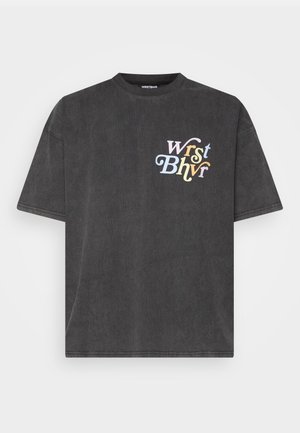 T-shirt gris foncé à manches courtes avec le logo texte multicolore "WRST BHVR" sur le côté gauche de la poitrine.