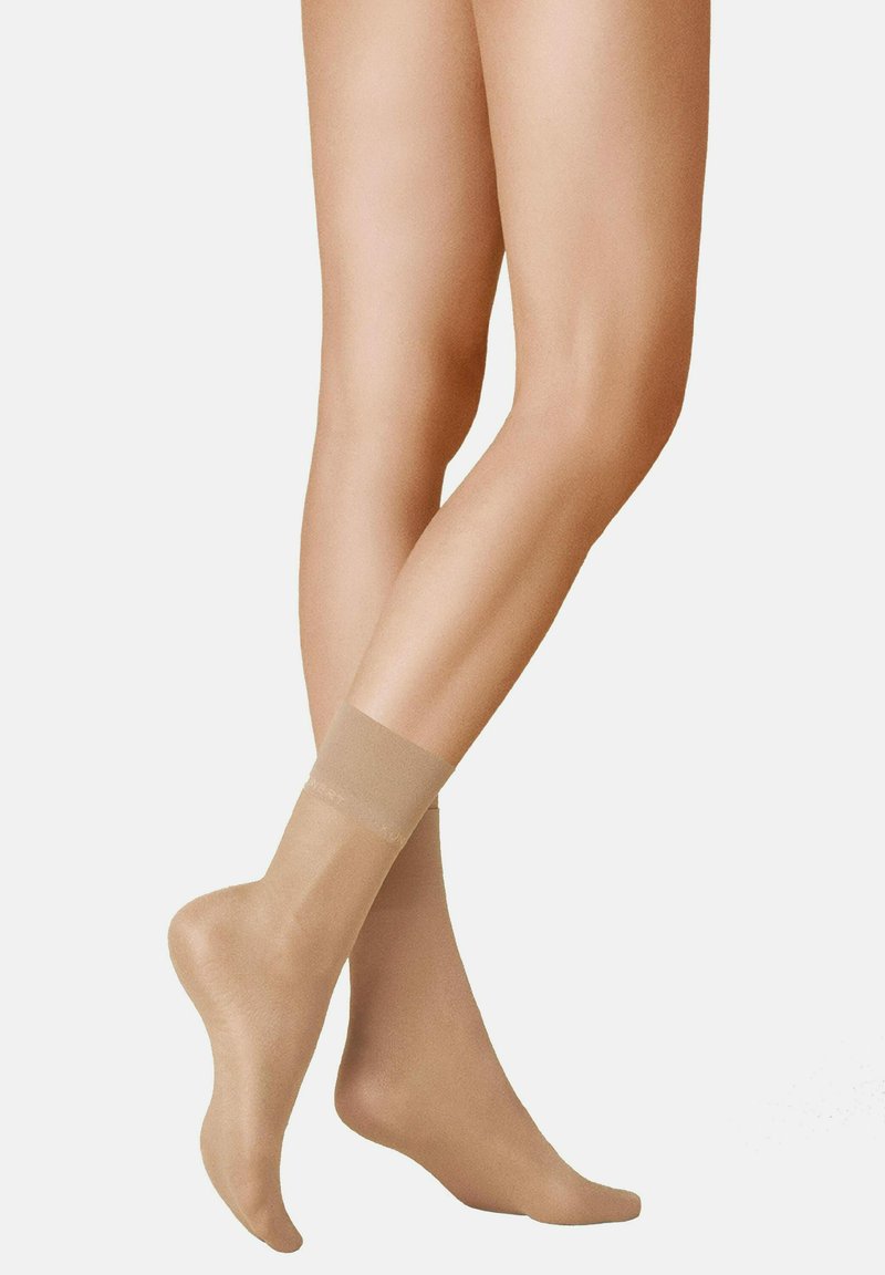 Beige sheer socks with a smooth texture, ankle length, featuring a transparent band at the top. Suitable for dress or casual wear.