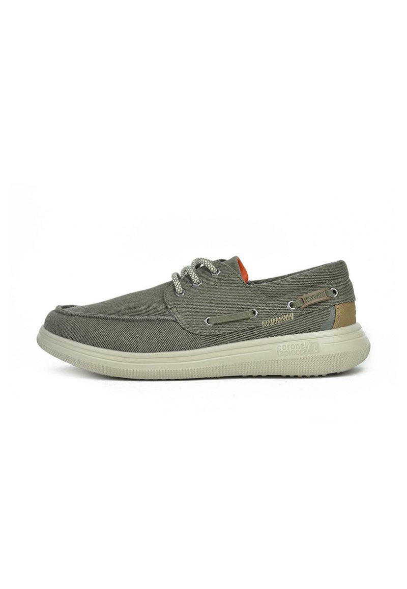 Zapatillas de barco de lona verde con tejido texturizado, suela de goma blanca y cordones grises. Presenta acentos laterales y un forro naranja.