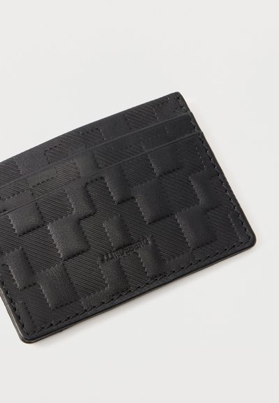 Μαύρο δερμάτινο θήκη καρτών με ανάγλυφο γεωμετρικό σχέδιο και διακοσμητική ραφή, με δύο θήκες για κάρτες σε απλό λευκό φόντο.