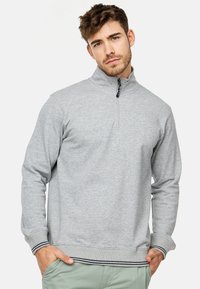 Szary polarowy sweatshirt z ćwierć zamkiem, z prążkowanymi mankietami i dołem, z czarno-białymi paskami oraz miękką, teksturowaną tkaniną.