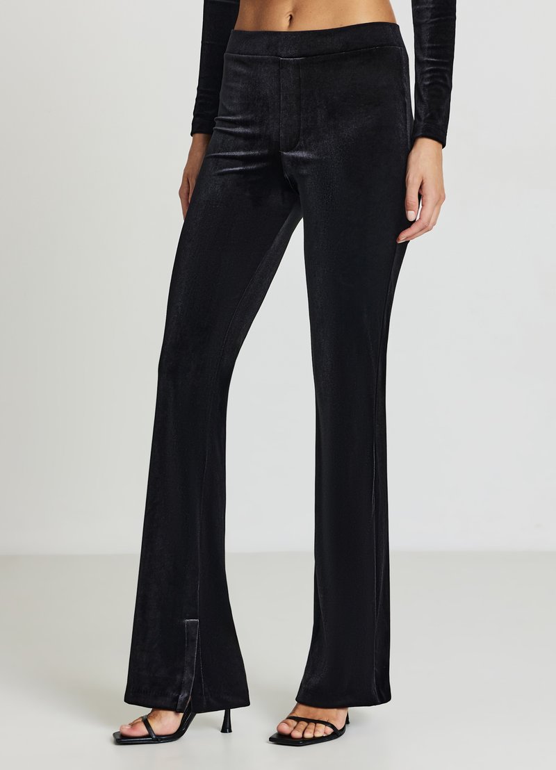 Pantalon évasé en velours noir avec une texture lisse, doté d'une fente latérale à l'ourlet et d'une taille ajustée. Conçu pour une coupe sur mesure.