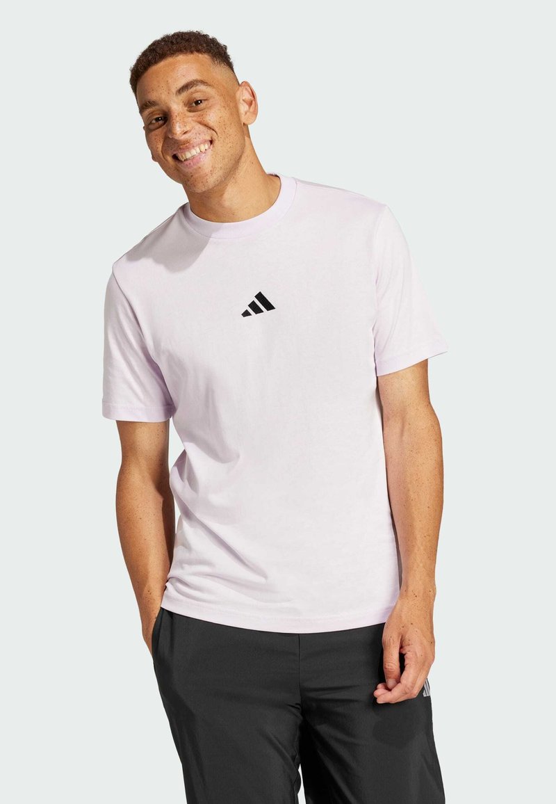 Světle fialové bavlněné tričko s krátkým rukávem, s černým logem Adidas na hrudi a designem s kulatým výstřihem.