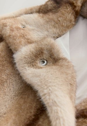 Weicher, hellbrauner Kunstpelzmantel mit plüschiger Textur, ausgestattet mit silberfarbenen Hardware-Details und einem satinierten Innenfutter.