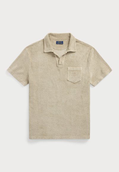 Polo beige à manches courtes en tissu éponge doux, avec un col à trois boutons et une poche poitrine arborant un discret logo brodé.