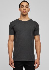 Camiseta de manga corta y cuello redondo en tejido gris oscuro. Textura suave, diseño sencillo y corte regular. Sin patrones ni acentos visibles.