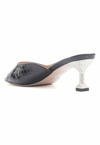Black patent leather slide shoe with a curved open toe and unique rhinestone-embellished heel. Smooth texture with a glossy finish.