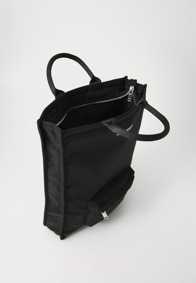 Black nylon tote bag with two handles, a zippered main compartment, and an exterior zip pocket. Smooth texture and minimalistic design.