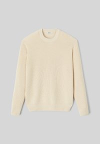 Pull en maille côtelée couleur écrue, avec un col rond et des manches longues. Le matériau présente une texture douce avec une coupe décontractée.