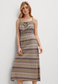 Maxikleid mit dünnen Trägern, verfügt über ein mehrfarbiges Zickzackmuster in Lila-, Grün- und Gelbtönen. Mit gerafftem Taillendetail.