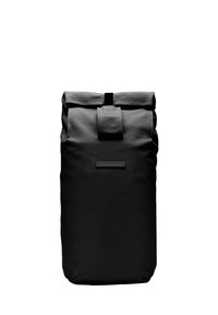 Sac à dos noir à rabat fabriqué en tissu texturé, doté d'une sangle de fermeture à l'avant et d'une petite étiquette. Design simple et fonctionnel.