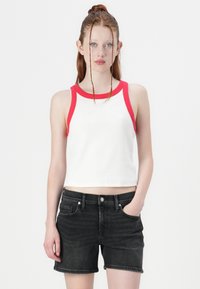 Biely cropped top s červeným lemovaním, spárovaný s čiernymi denimovými šortkami, s klasickým strihom a minimalistickým dizajnom.