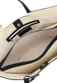 Borsa tote nera e crema con esterno in tela strutturata e dettagli in pelle liscia. Interno con tasca con cerniera e fodera beige.