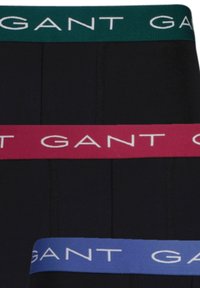 Svart boxerbriefs med elastisk midjebånd i grønn, rosa og blå med "GANT"-logo i hvitt. Glatt tekstur og tettsittende fasong.