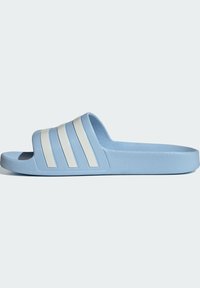 Blue slide sandals featuring a textured upper, three white parallel stripes, and a solid blue rubber sole. Minimalist and open-toed design.