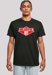 Black cotton t-shirt featuring a bold red and white "BEASTIE BOYS" logo in a diamond shape on the front. Short sleeves, crew neck design.