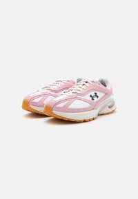 Scarpe da ginnastica rosa e bianche realizzate in materiali mesh e suede, forma arrotondata, suola testurizzata e un logo nero sul lato.