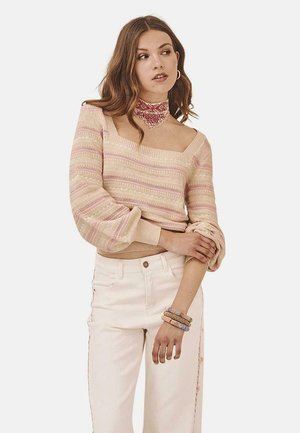 Suéter de punto con diseño off-shoulder, patrón a rayas en colores pastel, mangas globo, combinado con jeans blancos de tiro alto.
