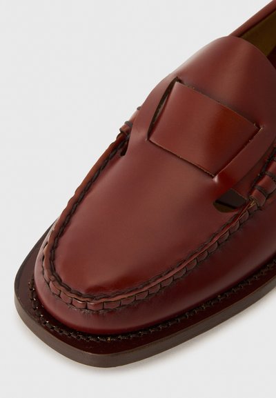 Braune Lederloafers mit glatter Oberfläche, ausgestattet mit einer gestickten Borte und Aussparungen; runde Zehenform und flacher Absatz.